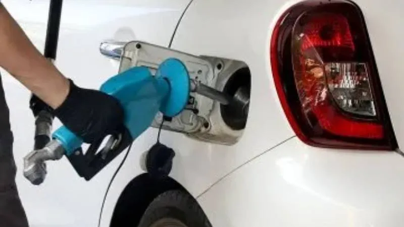 Persona cargando combustible en una estación de servicio de Rosario.
